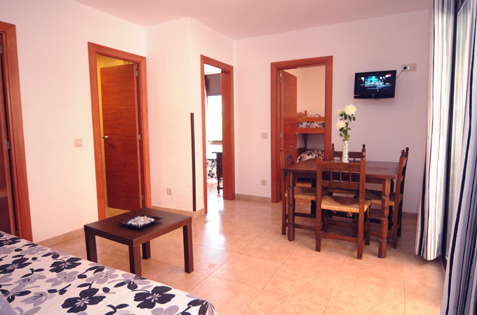 der Wohnbereich des Apartments mit Esstisch, Sofa und Fersehr